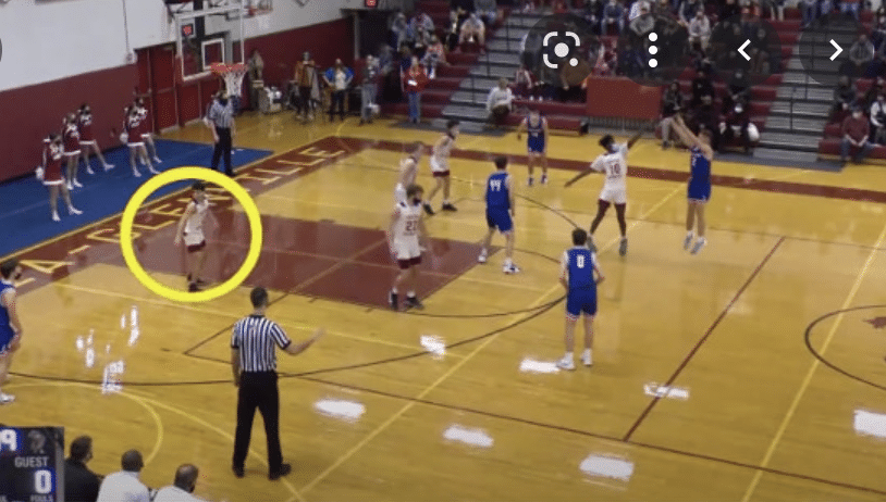 Player is highlighted with a circle while playing a youth basketball game